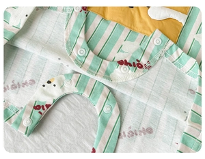 Close-up of green striped baby romper featuring snap buttons and a yellow pocket detail