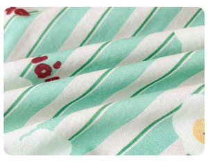 Detail of soft combed cotton fabric featuring mint green stripes and cute cartoon patterns