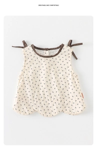 Detail view of baby sleeveless floral top with ribbon ties and small bow patterns
