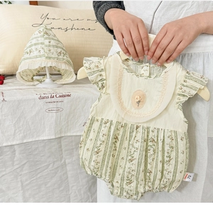 Detail of cotton floral baby bodysuit with ruffled edges and rose embroidery