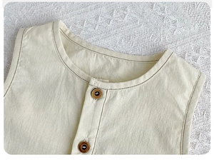 Detailed macro view of the round neckline and fashion buttons on a cotton baby romper