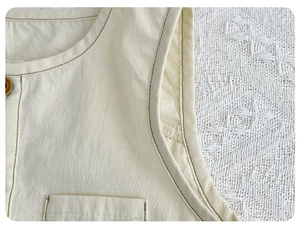 Detail of baby cotton romper featuring wooden buttons and soft breathable fabric texture