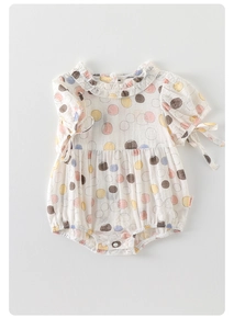 Detail view of baby romper featuring ruffled collar and colorful polka dot pattern