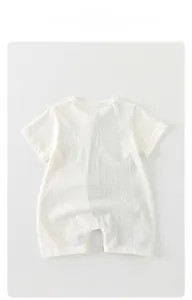 Detail of white cotton baby romper with round neck and breathable summer fabric