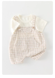 Close-up of baby cotton summer set with bear pattern overalls and wood grain buttons