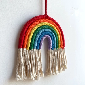 Detail of handmade rainbow wall hanging decoration with cotton rope and white fringe tassels