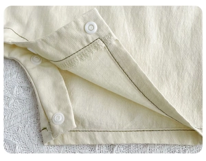Detailed close-up of premium cotton fabric texture and snaps on baby bodysuit