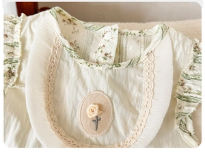 Close-up of baby romper featuring vintage lace collar and 3D fabric rose detail
