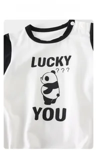 Detail of baby bodysuit with panda print and white resin shoulder buttons for easy dressing