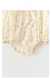 Détail du body bébé en coton fleuri montrant le tissu respirant et les boutons pression