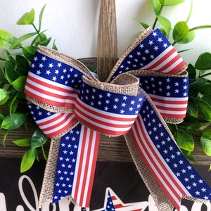 Patriotic Independence Day bow decoration with US flag stars and stripes on wood base