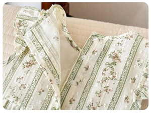Detail of floral baby bodysuit featuring Swiss dot cotton fabric and snap fasteners