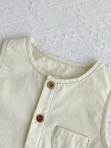 Short sleeve baby cotton romper in creamy white with wooden buttons and front pocket