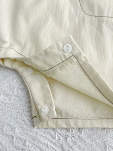 Soft cotton baby romper in cream yellow with white resin snap buttons for easy dressing