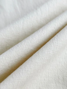 Short sleeve baby romper in cream cotton linen blend fabric with woven texture detail