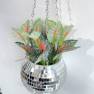 Close-up of hanging disco ball planter with vibrant faux foliage and silver metal chains