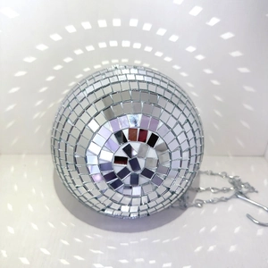 Disco ball hanging planter reflecting shimmering light patterns on a clean white wall