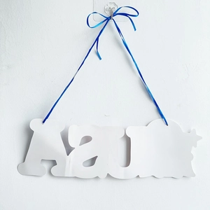 Close-up of white letter door hanger with blue ribbon for USA Independence Day decor