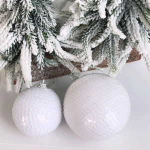 Close-up of white sequin Christmas balls with scales texture and silver hanging loops