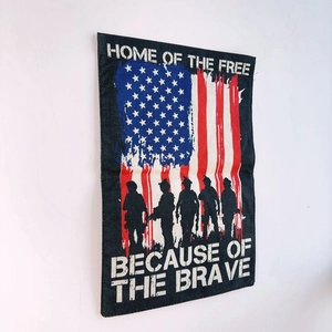 Detail of burlap garden flag with patriotic soldier silhouettes and text engraving
