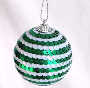 Close-up of a Christmas ball ornament featuring green and white sequins in a striped pattern