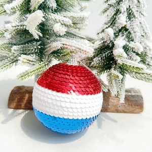 Close-up of red white and blue sequin US Independence Day ornaments with silver caps