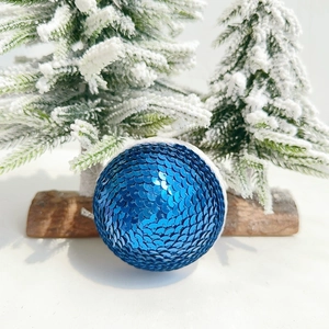Close-up of sparkling blue sequined ornament with silver string for festive decoration