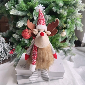 Cute sitting Christmas reindeer plush doll with red hat and scarf on book decor