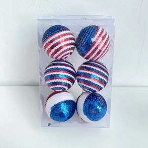 Macro detail of six glittery red white and blue sequined hanging balls in a clear display box