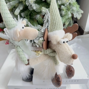Close-up of mint green Christmas reindeer plush dolls with knit hats and scarves decorations