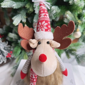 Macro shot of plush Christmas reindeer ornament with Nordic knit hat and warm red nose