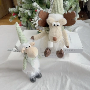 Close-up of white plush reindeer and sheep dolls with green checkered hats and scarves