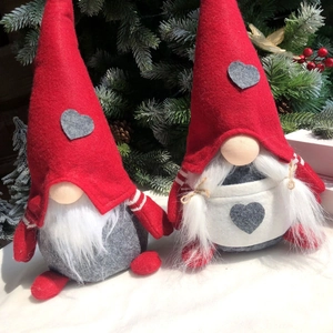 Dettaglio di gnomi natalizi con cappelli a cuore tra pigne e bacche rosse festose
