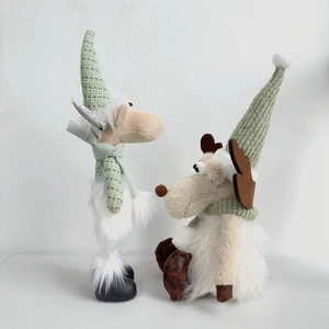 Close-up of sage green knit Christmas reindeer plush figures with white faux fur details