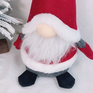Detail of Christmas gnome plush toy with red felt hat and long white faux fur beard