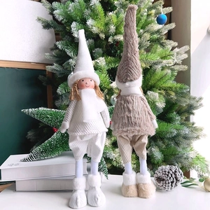 Detail of plush Christmas angel dolls with knitted hats and scarves on festive background