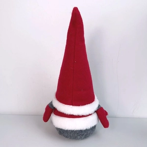 Detailed view of a plush Christmas gnome ornament with red felt hat and white faux fur trim