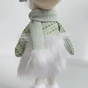 Detailed view of green tweed fabric, striped knit scarf, and soft white plush on a plush deer