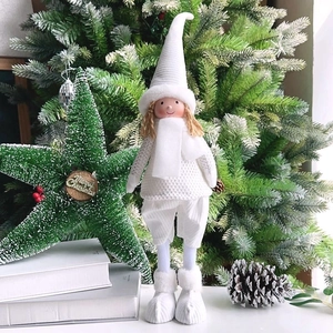 Detailed view of plush white Christmas elf doll with long legs against a festive tree