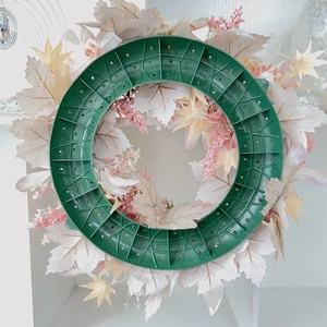 Vue arrière d'une couronne artificielle avec feuilles d'érable roses et décor citrouille