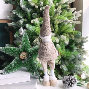 Detail of plush Christmas gnome with long legs and knitted tall hat on holiday decor