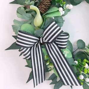 Artificial eucalyptus wreath with white berries, pine cone and black white striped bow