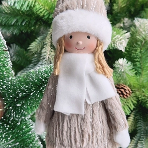 Close-up of a plush Christmas angel doll with white faux fur hat and golden braids