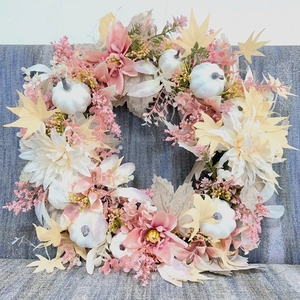 Détails de fleurs de dahlia roses et de citrouilles blanches sur une couronne d'automne