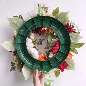 Close-up of a green plastic wreath frame with multiple holes for DIY Halloween decorations
