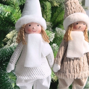 Close-up of adorable plush angel dolls with knitted hats and scarves for Christmas decor