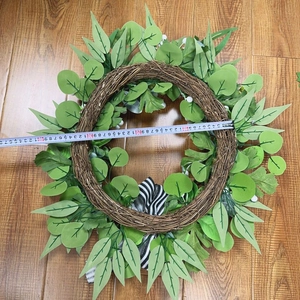 Detail showing artificial pumpkin wreath with green leaves and 40cm measurement scale