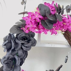 Detail of Halloween wreath with black roses, purple blossoms and dark foliage