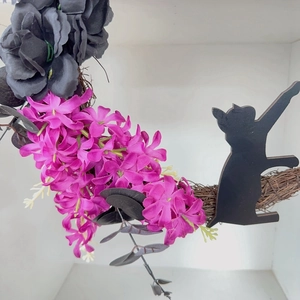 Detailed view of Halloween wreath with dark roses, purple flowers, and black cat silhouette