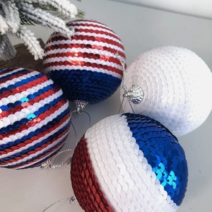 Détail de boules de décoration de fête à paillettes rouges, blanches et bleues suspendues